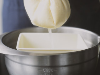 自制奶油奶酪,把牛奶混合物全部放入纱布，用手挤压，过滤掉一开始大量的乳清。等流出的乳清变少就可以放入模具中。乳清可以用来做面包或直接喝掉。挤出大部分水份就可以吃了。