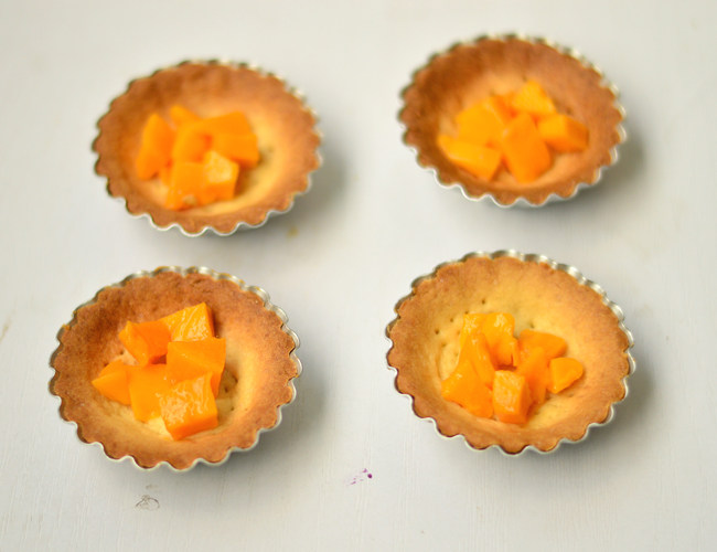芒果紫薯塔,在放凉的挞皮中放入芒果肉丁
