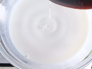 草莓装饰慕斯蛋糕,将牛奶加热至40度左右后将牛奶连碗一同取出加入沥干水的吉利丁片（吉利丁在30—40度的温度下融化不会影响其凝固力，如水温过高则会影响其凝固力）搅拌至完全融化，吉利丁完全溶于牛奶中。