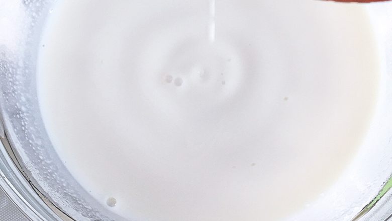 草莓装饰慕斯蛋糕,将牛奶加热至40度左右后将牛奶连碗一同取出加入沥干水的吉利丁片（吉利丁在30—40度的温度下融化不会影响其凝固力，如水温过高则会影响其凝固力）搅拌至完全融化，吉利丁完全溶于牛奶中。