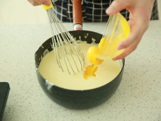 蓝莓乳酪派,加入蛋黄，继续用手动打蛋器搅拌至顺滑