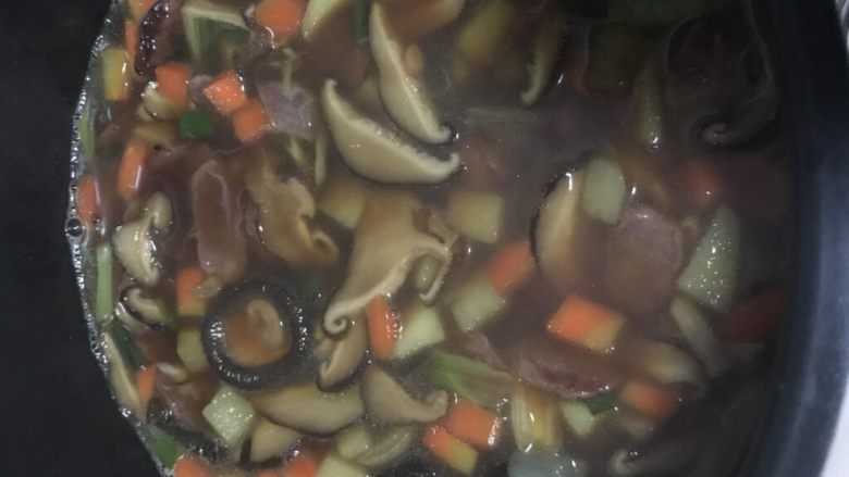 香菇腊肠焖饭,将煮开的浇头倒入锅里，汤汁没过配菜即可。