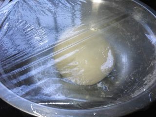 二分之一全麦粉的葡萄干吐司,取一个不粘的容器（如果没有，可以事先在容器内壁上涂上黄油防粘），放入面团，盖上盖子或保鲜膜，放入冰箱保存10小时。现在的天气室温低于冰箱……所以放外面也可以。