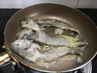 咸菜黄鱼面,取一小锅，倒少许油，加姜丝，把鱼骨放进去煎一煎