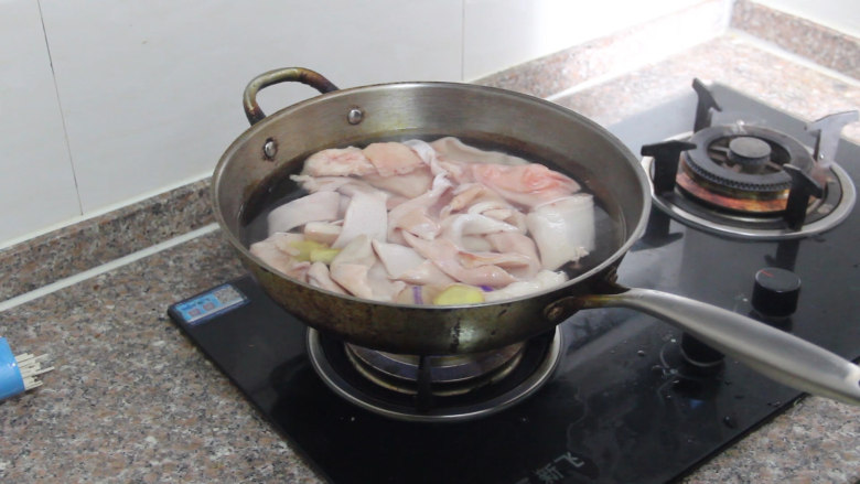 猪皮冻的家常做法,先把清洗干净的猪皮凉水下锅，加姜片、一勺料酒大火烧开煮十分，把猪皮上的油脂煮软。