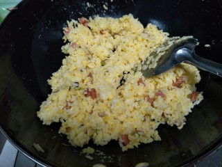 黄金蛋炒饭,把裹满蛋液的米饭倒进去翻炒，米粒一个个分离的时候加入盐翻炒均匀就可以出锅了