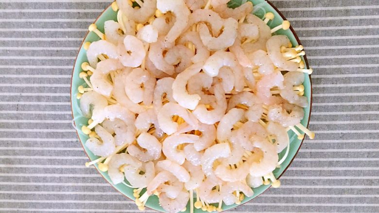 金针菇粉丝蒸虾仁,将腌制好的虾仁均匀的铺在金针菇上。