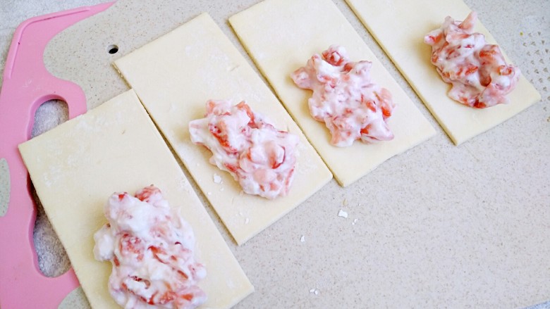 草莓奶酪派,挖一大勺奶酪草莓粒，在每块派皮上。