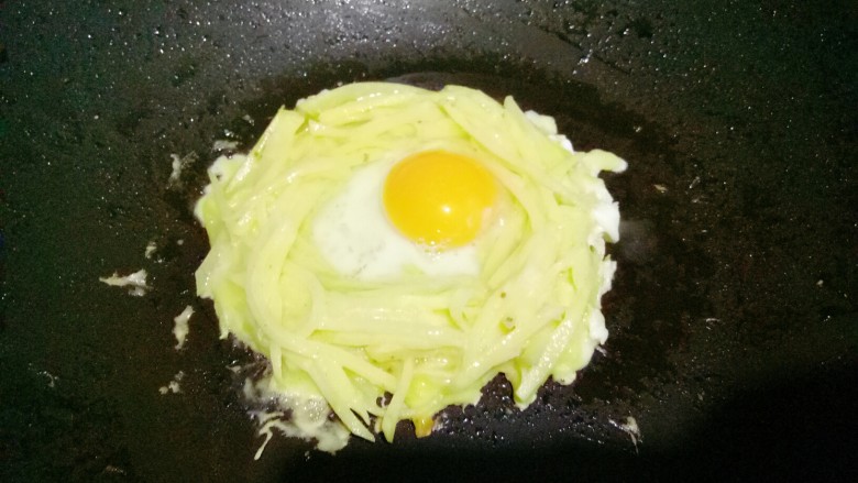 太阳蛋,土豆丝在平底锅中摊成鸟巢的形状，然后中间打入一个鸡蛋