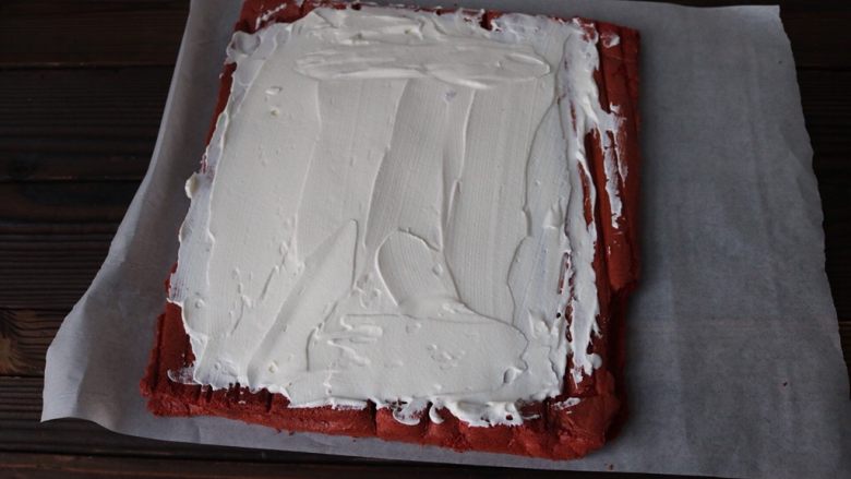 红丝绒蛋糕卷,<a style='color:red;display:inline-block;' href='/shicai/ 8197'>淡奶油</a>加柠檬汁、糖粉打发至9分，涂抹至蛋糕上