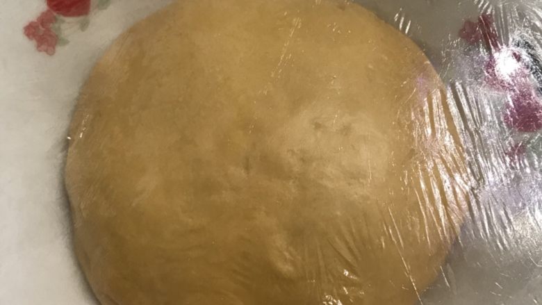南瓜花环面包,拿出来揉圆，放入预先抹好油的碗中，盖上保鲜膜，送进发酵箱温度在28度进行基础发酵。