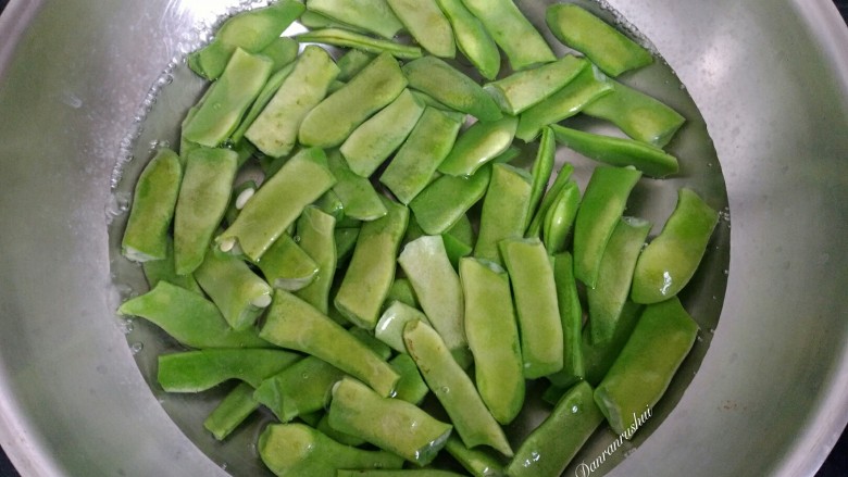 宽扁豆炒麻辣香肠,把扁豆放入水中焯熟。