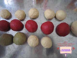 情人节礼物🎁玫瑰花土司,发酵好的面团排气松弛15分钟。将红面团分成5个大小递增的小面团，绿面团均分为两个小面团，白色分成7个小面团和一个最后包裹用的大面团
