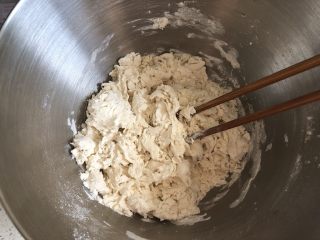手工韭菜鸡蛋饺子,面粉加2g盐，一边倒入清水一边搅拌，成棉絮状