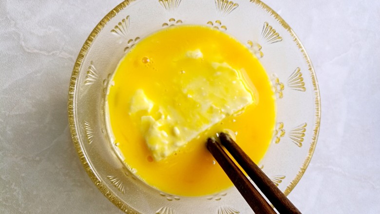 炸素"鸡"排,将沾上淀粉的豆腐放入蛋液中裹上蛋液。