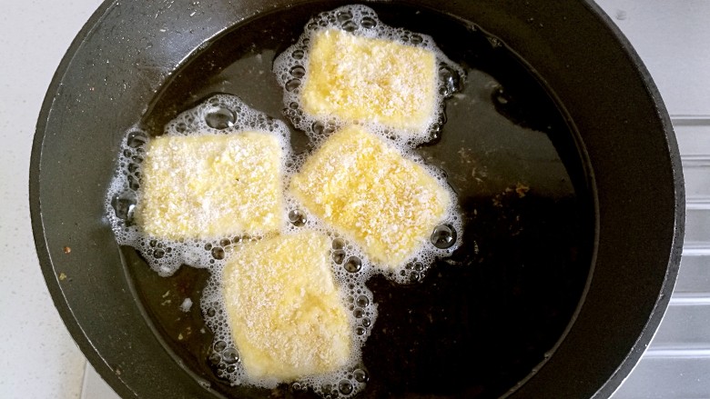 炸素"鸡"排,然后改小火把豆腐一块一块的放入油锅中炸，不要一次性全放入，分批的炸。