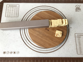 香橙奶酥饼干,取出冷冻后的饼干条，撕掉保鲜膜后，将饼干模倒扣，刀靠着饼干模侧面切出0.7cm左右厚薄的片。
