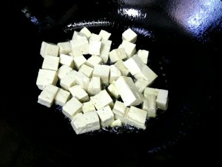 宫保豆腐,锅里剩适量底油，放入豆腐，先不要用铲子铲，拿着炒锅前后晃动，不粘锅，待其变焦黄，用铲子小心翻动