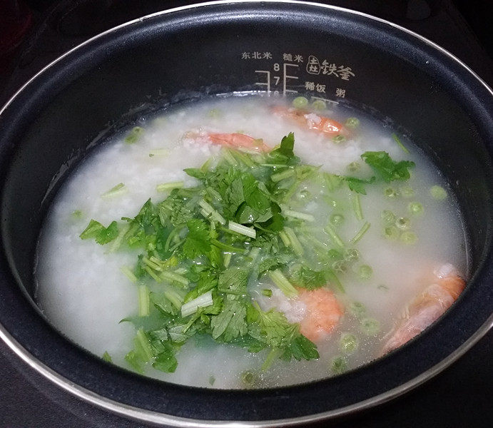 #电饭煲# 蔬菜海鲜粥,过10分钟再打开倒入芹菜碎、同样搅拌下加盖继续