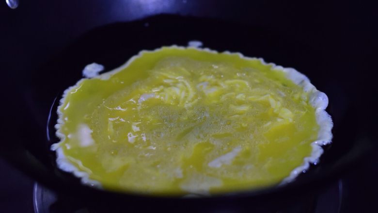 菠菜鸡蛋手擀面,油锅加热一汤匙油后转小火，倒入鸡蛋液。