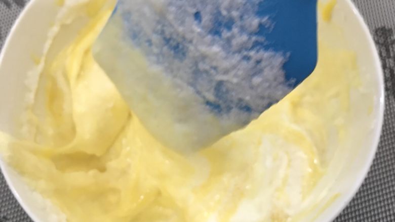 奶牛蛋糕卷,抓紧混合蛋黄糊和蛋白霜部分，先取三分之一蛋白霜至蛋黄糊中，切拌混匀