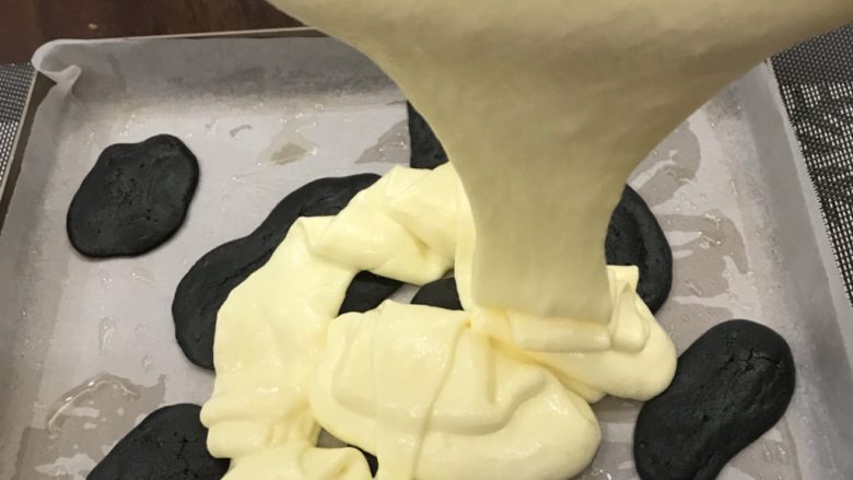 奶牛蛋糕卷,快速将混匀的蛋黄蛋白糊倒入已经定型好的烤盘中