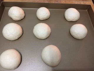 奶香小馒头,放入烤盘再次发酵至蓬松后，在面包的表皮刷上蛋液后放入烤箱120度火温，上下火，低层18分钟后，将烤盘拿出来，可以在表皮上刷一些蜂蜜看起来更漂亮一些