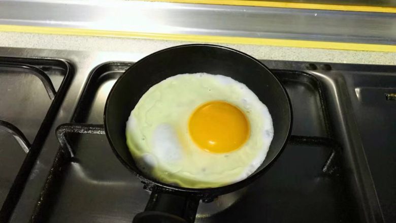 双层鸡肉米饭堡,小锅里薄薄一层油，煎一粒整蛋。