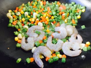 四季豆鲜虾意面,把蔬菜拨在锅的一边，放入虾仁，煸炒虾仁至颜色变粉色，然后和蔬菜炒匀。