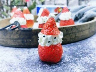 奶油草莓圣诞老人,再用熟黑芝麻，做圣诞老人的眼睛和鼻子。