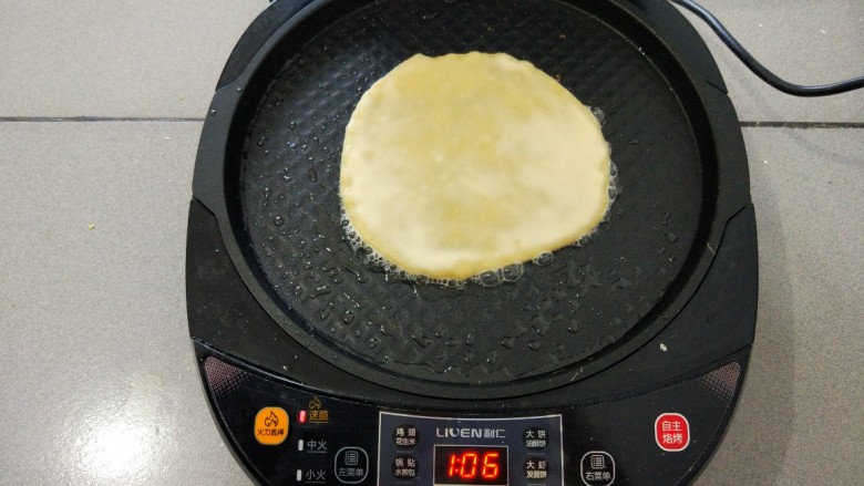 金灿灿—鸡蛋灌饼,预热完毕，倒一些油用硅胶刷刷匀，放入饼胚，电饼铛上层也要抹油，盖上盖子。