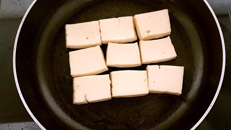 干锅千页豆腐,锅里加入1勺大豆色拉油，烧热后加入千叶豆腐，小火煎制，底面微黄就翻面