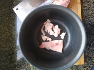 电饭煲-豆角焖面,肥肉切小片儿留下肉皮。放进电饭煲里，小火加热。（即电饭煲上的蒸煮键）