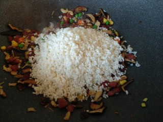 真正的生炒腊味糯米饭,加入沥干水的糯米翻炒均匀，炒干水分后