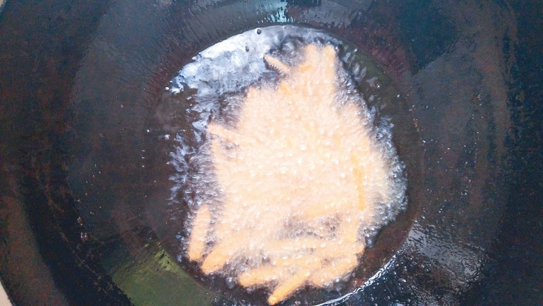 铁板鸡脆骨,花生米炸好捞出来，放入胡萝卜炸两到三分钟！收干胡萝卜的水分即可！