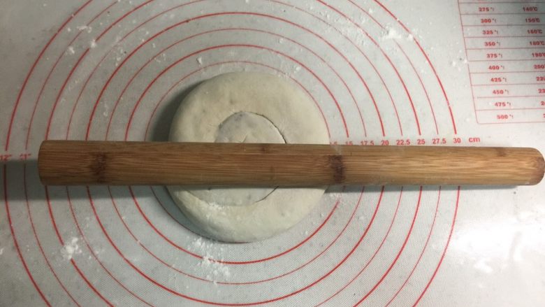 芝麻酱红糖饼,把面卷用手轻轻按扁，再用擀面杖擀圆。电饼铛可以开始预热。