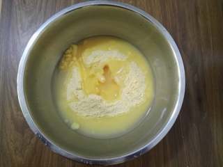 大枣花生玉米面发糕,将玉米面倒入盆中，加入开水用筷子搅拌均匀。