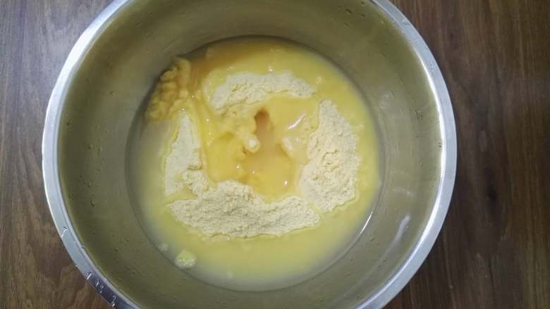 大枣花生玉米面发糕,将玉米面倒入盆中，加入开水用筷子搅拌均匀。
