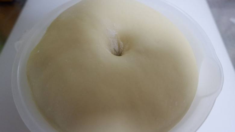 豆沙花环面包,放温暖处发酵至2.5倍至两倍大，手指沾面粉插孔面团不回缩，发酵完毕。
