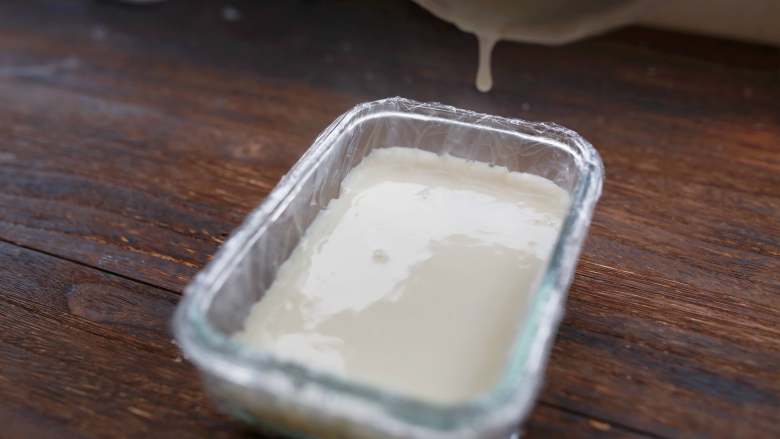 香脆炸牛奶,取方形碗，放上保鲜膜垫底，倒入煮好的牛奶，厚度大约2-3cm即可。