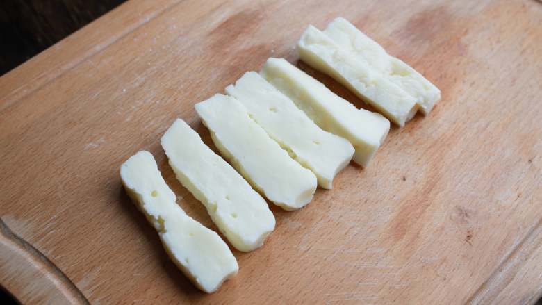 香脆炸牛奶,牛奶放凉后，盖上一层保鲜膜，冷藏30分钟，用冷水粘湿刀面，将奶块切成4-5cm的长条状。