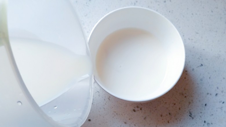 简易双皮奶,沿着边缘慢慢地把牛奶倒到有奶皮的碗里，要慢要慢！倒好后，用保鲜膜封口，然后用牙签在保鲜膜上戳几个孔。