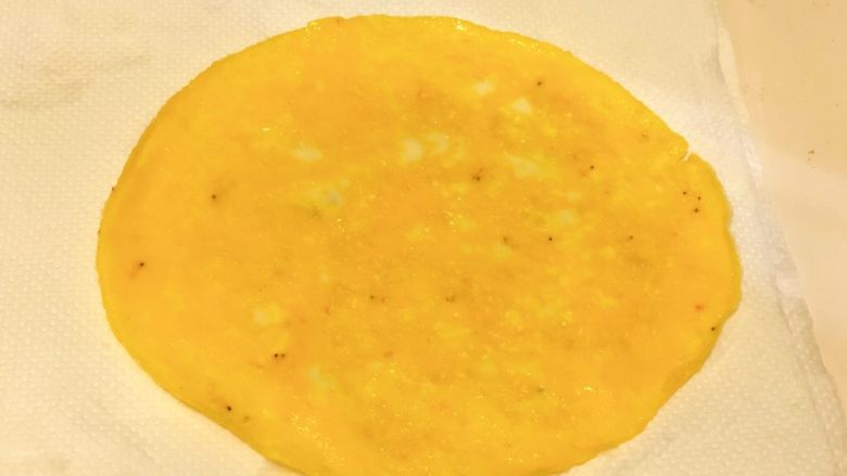 元气果蔬十全蛋卷（12m+）,将煎好的鸡蛋放到吸油纸上，吸去多余的油脂。