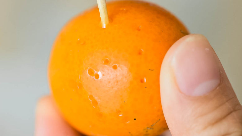 能治嗓子疼的咸金橘,用牙签在金桔上扎小洞。

