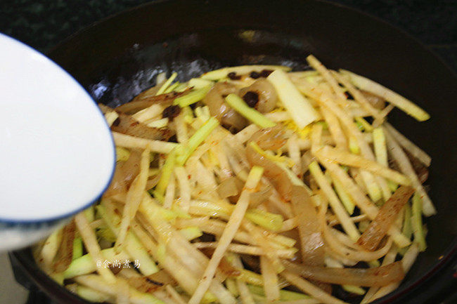 猪皮炒大头菜,撒点清水，拌匀、遮上锅盖焖煮片刻，让食材快速软化；