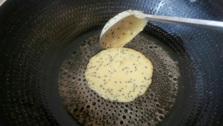 黑芝麻蛋卷，十分钟搞定早餐,将蛋糊倒入刷好黄油的平底锅上，小火烧。