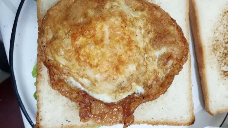 快手早餐三明治,也可以：

② 煎成荷包蛋。

荷包蛋可以煎焦一点，吃起来脆脆的，别有一番风味。

