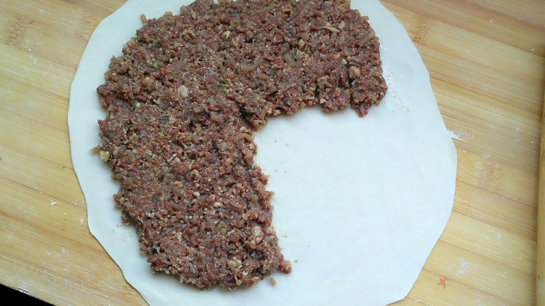 牛肉饼,看图，把肉馅铺上，留四分之一空下，另外肉馅也不要铺到太靠边，留两厘米。 肉馅铺多厚，看你有多少馅