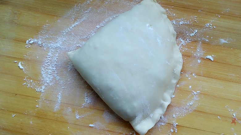 牛肉饼,再折下来，成了一个三角状，把所有空白边都捏合，这样就不会露馅了。
