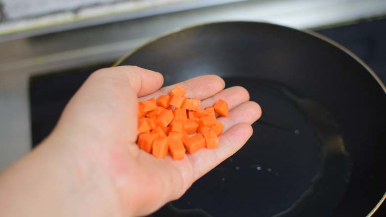 黄瓜蛋炒饭,锅中油加热，加入胡萝卜，炒一分钟